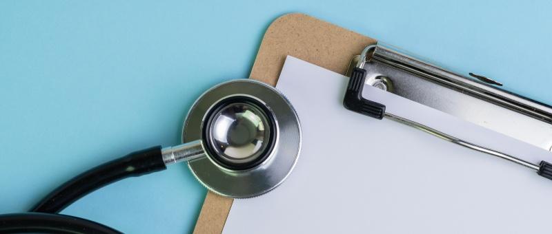 Stethoscope and clipboard against blue background.